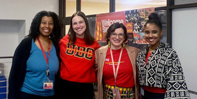 Four UDC staff members hugging and smiling,