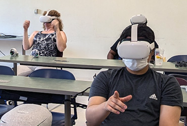 A few students in a classroom with VR headsets on