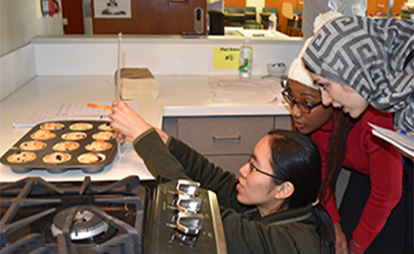 Two women cooking muffins