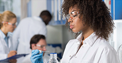  A woman in a lab coat holds a test tube, focused on her scientific work in a laboratory setting.