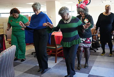 A group of UDC staff people doing the electric slide.