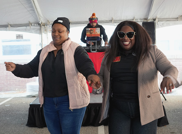 Two women dancing and smiling.