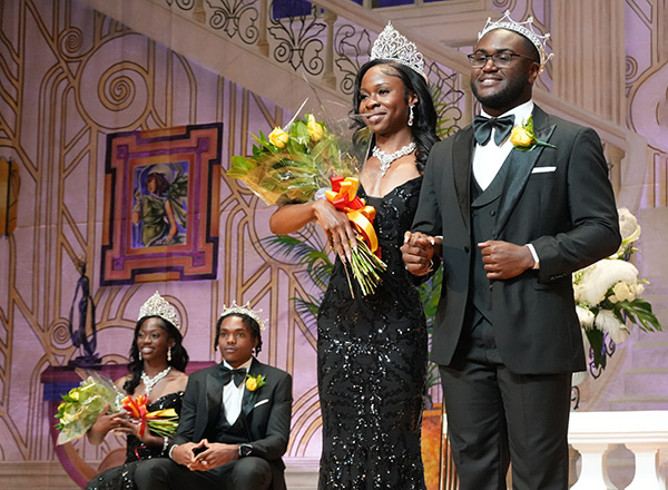 A woman and a man in formal attire and crowns.