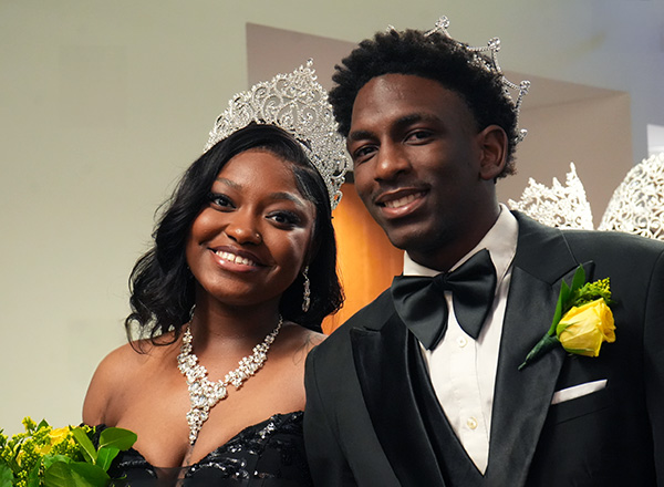 A woman and a man in formal attire wearing crowns.