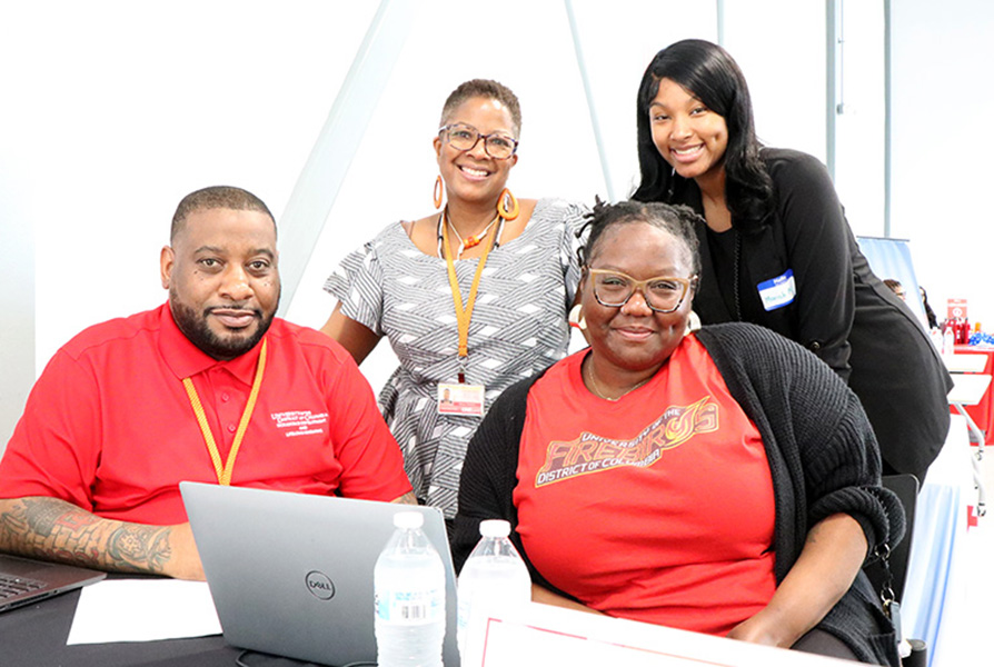 Four people sitting at a table at a career fair