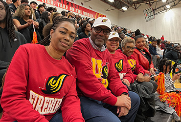 UDC staff at a basketball game wearing red and yellow school apparel